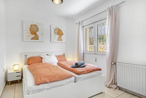 a white bedroom with a bed with an orange blanket at Adriana in Denia