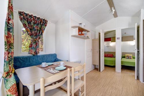 ein kleines Zimmer mit einem Tisch und einem blauen Sofa in der Unterkunft Bungalow Cádiz Costa in Chiclana de la Frontera