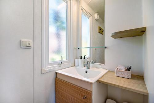 uma casa de banho com um lavatório e uma janela em Bungalow Cádiz Costa em Chiclana de la Frontera