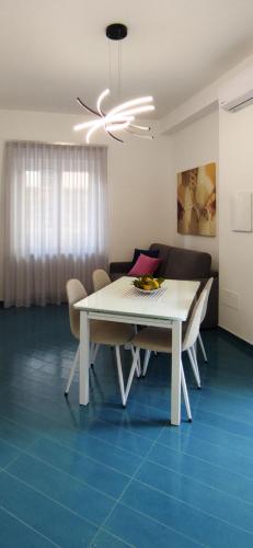 a white dining room table with chairs and a ceiling fan at Casa Fortuna a DUE passi dal Mare in Cetara