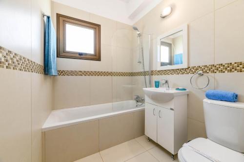 a bathroom with a tub and a sink and a toilet at Kymma Bungalow #2 in Ayia Napa