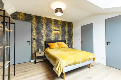 a bedroom with a bed and a brick wall at LE PADDOCK "Maison 220 m2 pour 8 à 12 personnes" in Montfort-le-Gesnois