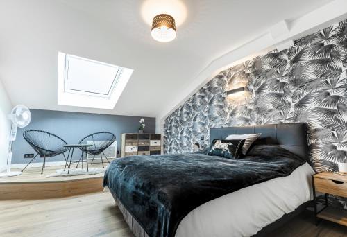 a bedroom with a large bed with a black blanket at LE PADDOCK "Maison 220 m2 pour 8 à 12 personnes" in Montfort-le-Gesnois