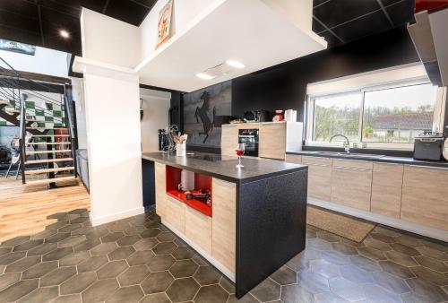 a kitchen with a black counter and a sink at LE PADDOCK "Maison 220 m2 pour 8 à 12 personnes" in Montfort-le-Gesnois