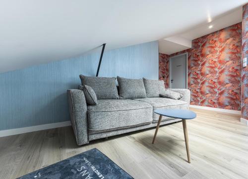 a living room with a couch and a table at LE PADDOCK "Maison 220 m2 pour 8 à 12 personnes" in Montfort-le-Gesnois