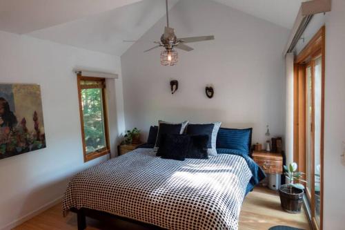1 dormitorio con 1 cama y ventilador de techo en Whimsical Lakefront Chalet en Monticello