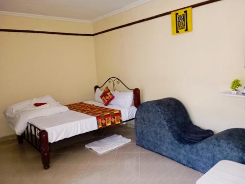 Habitación con 2 camas y silla azul en Pury Bnb's, en Marigat