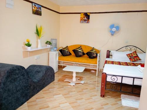 1 dormitorio con 2 camas y sofá en Pury Bnb's, en Marigat