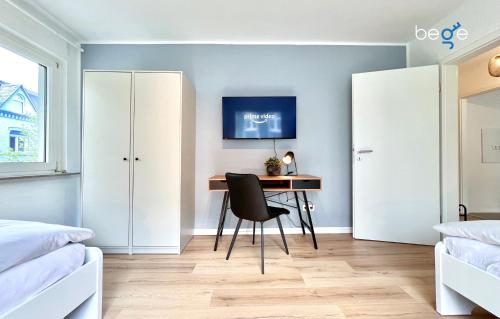 een slaapkamer met een bureau met een stoel en een bed bij BEGE APARTMENTS Business Residence in Hagen
