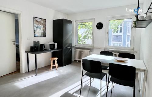 een keuken met een tafel en stoelen in een kamer bij BEGE APARTMENTS Business Residence in Hagen