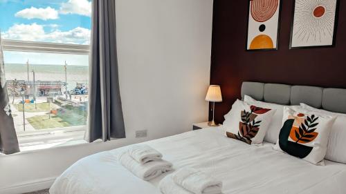 a bedroom with a bed with a view of the beach at Eden Apartments in Bridlington