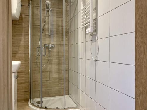 a shower with a glass door in a bathroom at A cozy house close to the beach, azy in Łazy