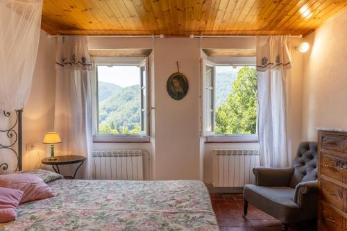 ein Schlafzimmer mit einem Bett und einem Stuhl sowie zwei Fenstern in der Unterkunft La Piana in Pian dʼOrsina
