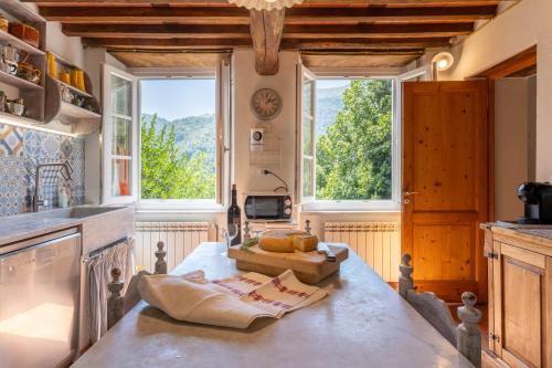 eine Küche mit Fenstern und einer großen Arbeitsplatte in der Unterkunft La Piana in Pian dʼOrsina