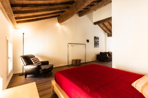 a bedroom with a red bed and a chair at Blasmatorti Suite in Reggio Emilia
