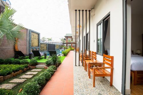 a balcony with chairs and a bed on a building at Aurora House in Phu Quoc