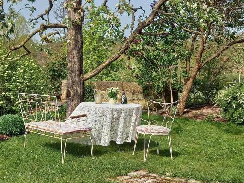 a table and two chairs in a yard at Ferienwohnung Pfadenhauer in Pfarrweisach