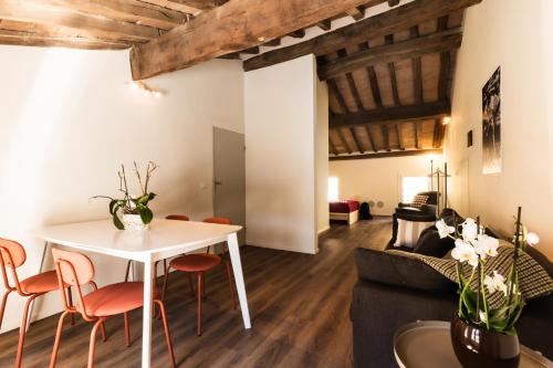 un soggiorno con tavolo bianco e sedie arancioni di Blasmatorti Suite a Reggio Emilia