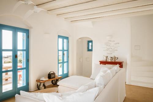 biały salon z białymi meblami i oknami w obiekcie Cemilion w Koufonisii