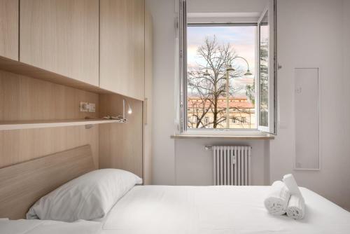 - une chambre avec un lit blanc et une fenêtre dans l'établissement Flats4rent Chiara, à Vérone