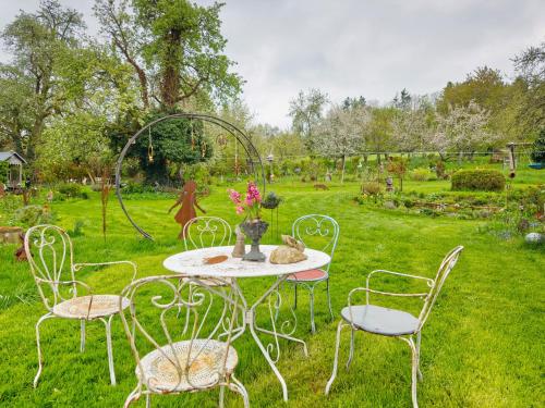 a table with chairs and a vase with flowers on it at Ferienhaus am Ried in Burgweiler