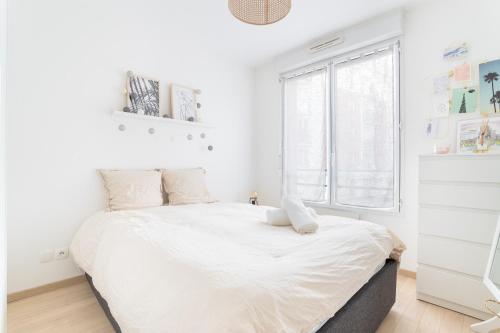 une chambre blanche avec un grand lit avec une fenêtre dans l'établissement Appartement Cosy - Vieux lille, à Lille