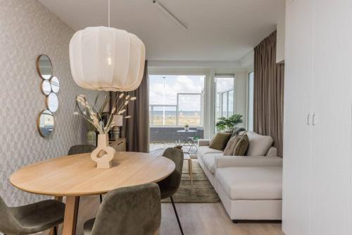 a living room with a table and a couch at Haya Seaview - The Pier in Scheveningen