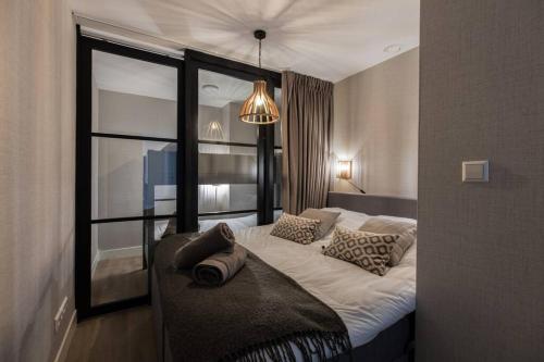 een slaapkamer met een groot wit bed en een raam bij Apartment The Pier in Scheveningen