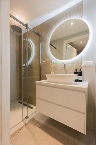a white bathroom with a sink and a mirror at Haya Seaview - The Pier in Scheveningen