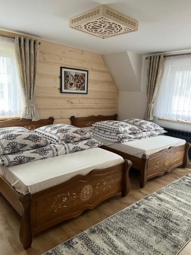 a bedroom with two beds and a chandelier at Pokoje u Magdusi przy termach in Witów