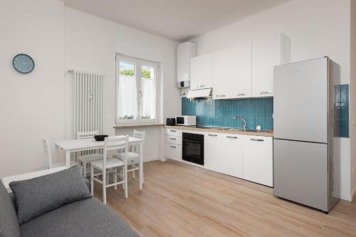 - une cuisine avec des placards blancs, une table et un réfrigérateur dans l'établissement Flats4rent Chiara, à Vérone