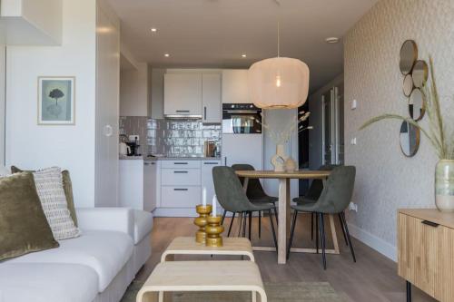 een woonkamer met een witte bank en een tafel bij Apartment The Pier in Scheveningen