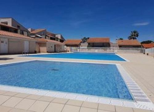 une grande piscine devant une maison dans l'établissement CLOS ST CYPRIEN Superbe T2 proche plage et port - terrasse - Piscine - parking, à Saint-Cyprien