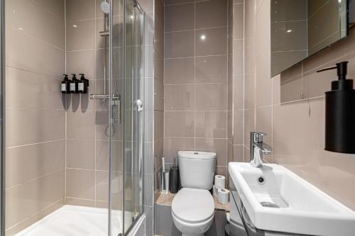 a bathroom with a shower and a toilet and a sink at West Hampstead Hub in London