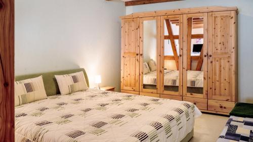 a bedroom with a bed and a large wooden cabinet at Ferienwohnung Strempel in Templin