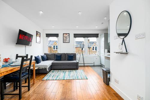 a living room with a couch and a table at West Hampstead Hub in London