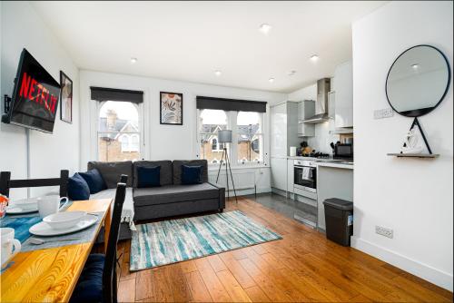 a living room with a couch and a table at West Hampstead Hub in London