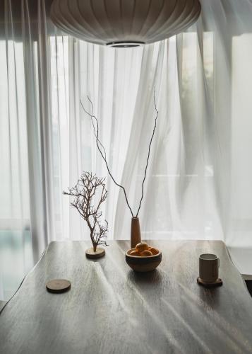 a table with a bowl of bread and a cup of coffee at We are now here in Busan