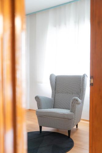 a chair sitting on a rug in a room at We are now here in Busan