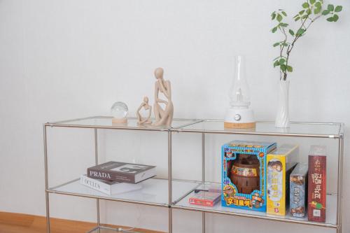 a glass shelf with a figurine and books at We are now here in Busan
