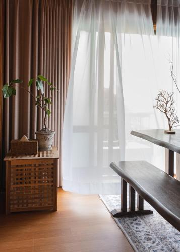 a living room with a bench and a window at We are now here in Busan