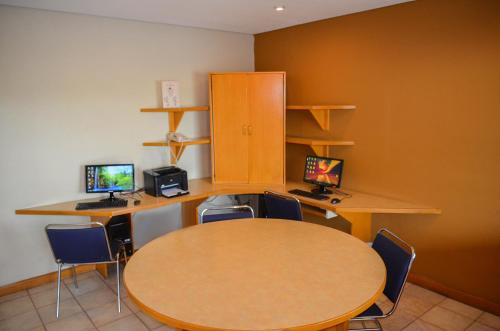 a conference room with a table and two computer monitors at Hotel Colonial Hermosillo in Hermosillo