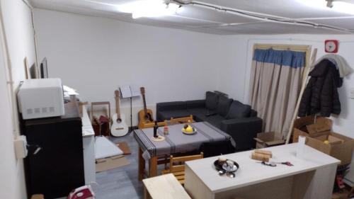Cette chambre comprend un salon doté d'un canapé et d'une guitare. dans l'établissement Departamento Centro, à Malargüe