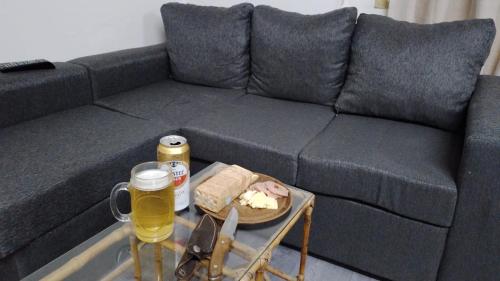 - un canapé avec une table et une assiette de nourriture et de bière dans l'établissement Departamento Centro, à Malargüe