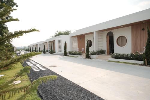 a row of white buildings with trees and plants at Wantanee Ville วันทนีย์วิลล์ in Ban Wang Sai