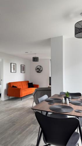 a living room with an orange couch and a table at Luxury Apartment by Noire Property in Manchester