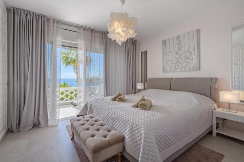 ein weißes Schlafzimmer mit einem großen Bett und einem großen Fenster in der Unterkunft 2 Bedroom Apartment - Terrace & Sea View - Los Gigantes in Acantilado de los Gigantes