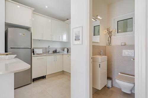 eine weiße Küche mit Spüle und Kühlschrank in der Unterkunft 2 Bedroom Apartment - Terrace & Sea View - Los Gigantes in Acantilado de los Gigantes