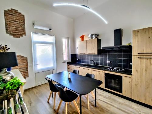 a kitchen with a table and chairs in a room at - SeaFront Deluxe Home- [Private Jacuzzi & Garden] in Marina di Carrara