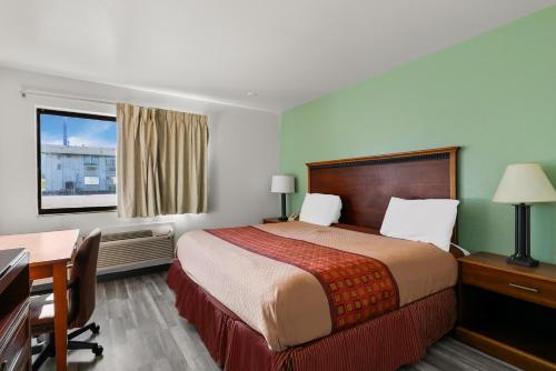 Habitación de hotel con cama, escritorio y ventana en Americas Best Value Inn - Lincoln Airport, en Lincoln